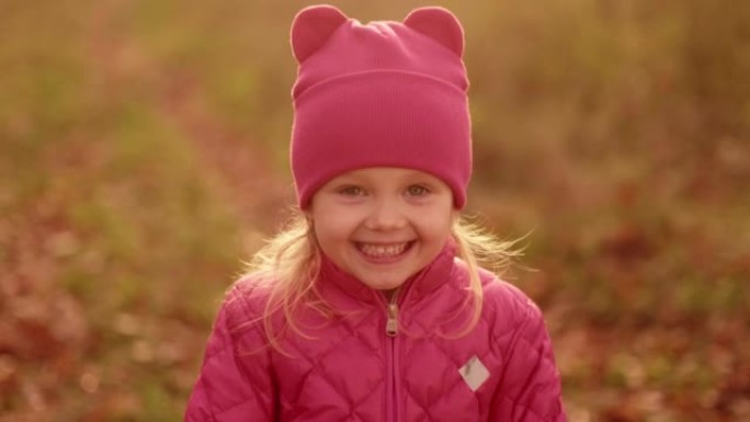 滑稽小女孩笑的肖像，特写。秋季公园可爱的孩子