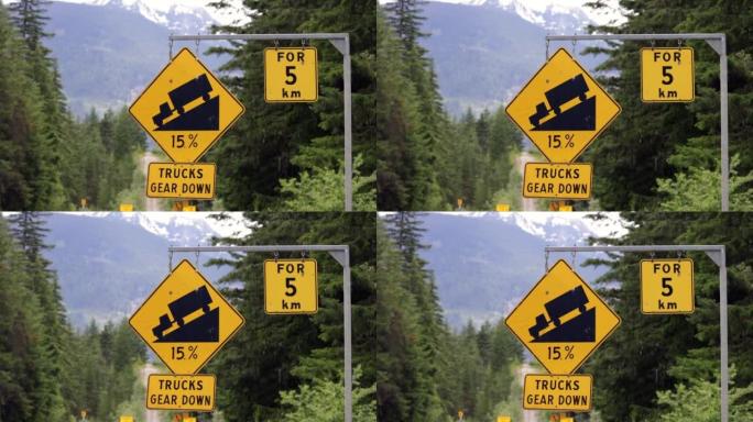 陡峭的山坡下降在加拿大不列颠哥伦比亚省99号高速公路上使用低档交通标志