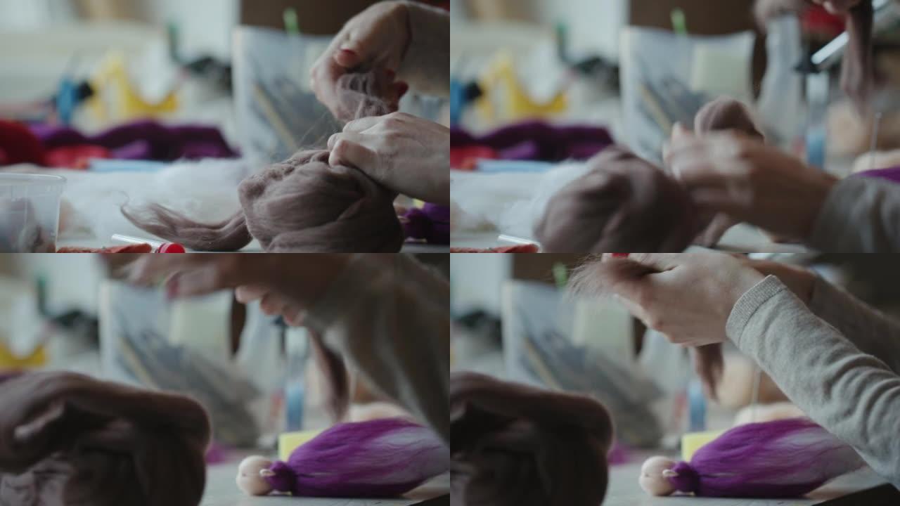 女性双手分开一块毡毛，用于制作娃娃