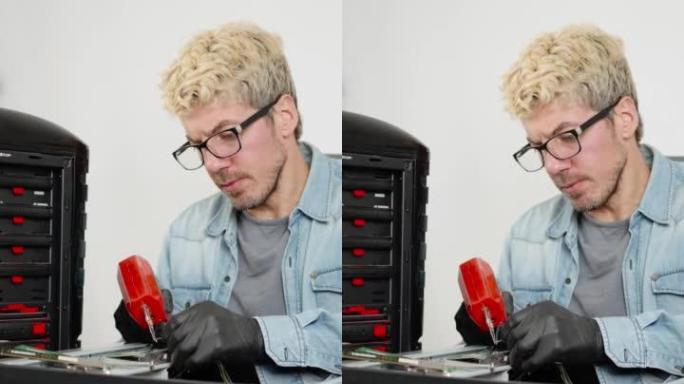 白人男子用拆焊枪焊接电脑。电脑维修服务概念