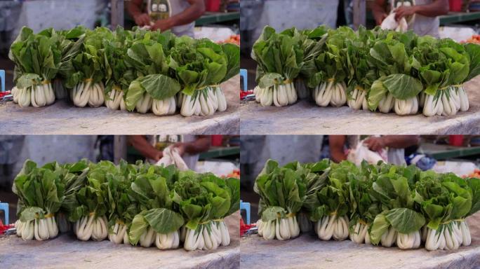 一捆捆新鲜收获的白菜蔬菜出售。