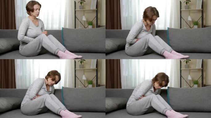 腹痛在月经期坐在沙发上的女人。