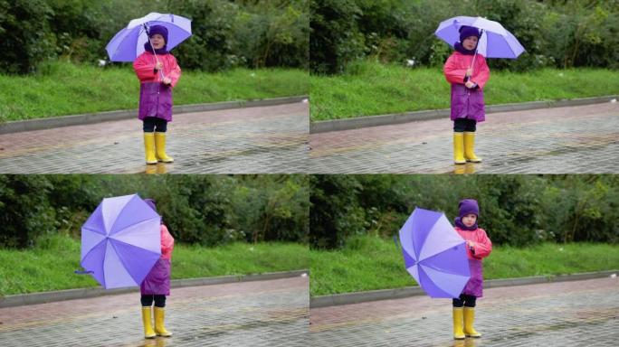 在秋雨中玩耍的孩子。带伞的孩子。任何天气下的户外乐趣。儿童防雨服、靴子和夹克。