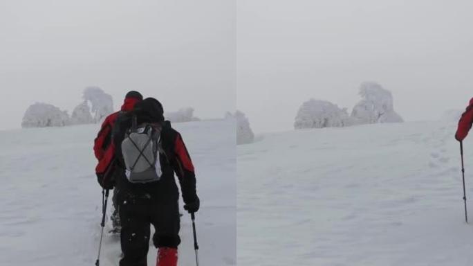 徒步旅行者在冬季徒步旅行时爬上斜坡。