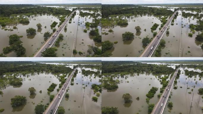 在经过洪水泛滥地区的道路上行驶的交通汽车的鸟瞰图