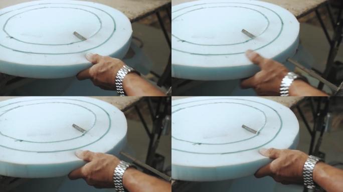 近景手男工人切割泡沫橡胶，用于生产家具厂的沙发特写镜头。