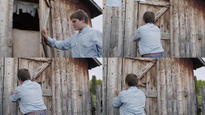 年轻的农民男孩在美国科罗拉多州一个小镇的家庭牧场上关闭并锁住了木制鸡舍或外部存储棚的门