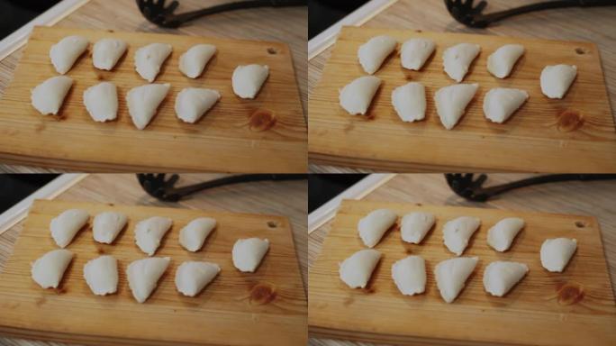 美味的自制生饺子躺在厨房的木板上。