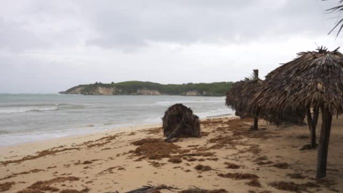 暴风雨过后的热带海滩。在刮风的天气中，由棕榈叶制成的落伞会冲向海岸海浪。澳门台风过后的海滨
