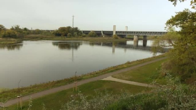 宽阔的镜头，可以看到一条槽桥，该槽桥充满水，穿过一条天然河流作为运输通道