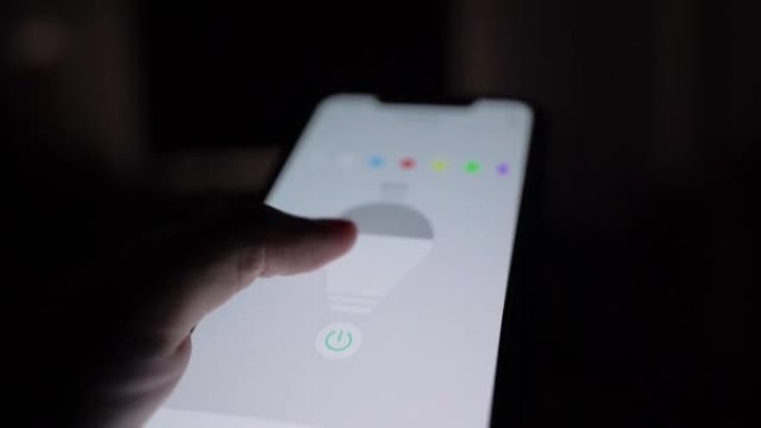 男人使用智能家居应用程序在家中控制灯光颜色。