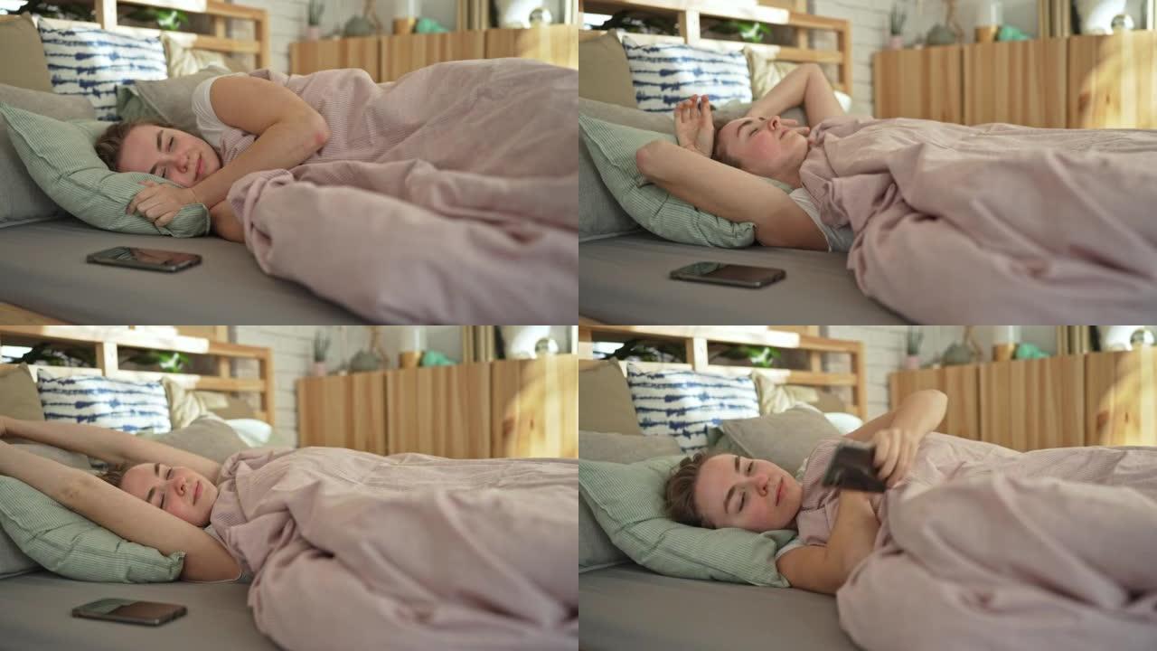 躺在床上的女人伸手去拿手机