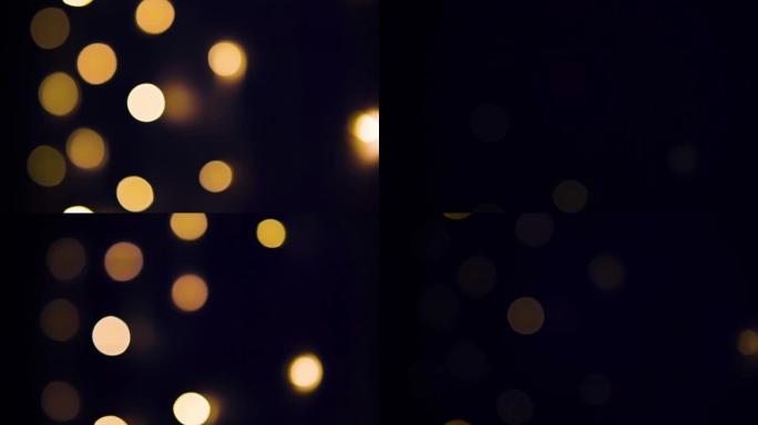 花环的灯点亮并在墙上熄灭。抽象模糊的灯光在黑色背景上闪闪发光。圣诞节或新年假期概念。