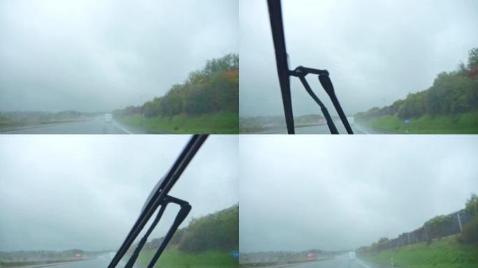 在雨中，在阴沉的天气里，在高速公路上行驶。雨刮器擦拭汽车雨水浸湿的挡风玻璃。版本3