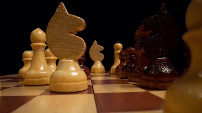 一个在棋盘上的白色木制象棋皇后的近景摄影摄影。流畅的相机运动上面的棋盘与黑白棋子。黑色背景。