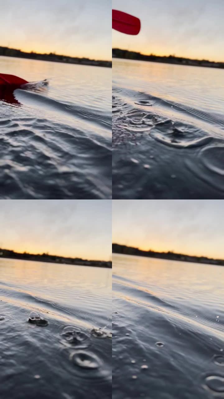 垂直屏幕: 在日落光线的背景下，在平静的水面上划桨，在皮划艇上进行户外活动，水上运动