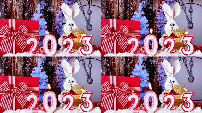 新年快乐2023。2023由蜡烛在节日圣诞背景与时钟拨盘。十二点前五分钟。白色的新年树，红球。倒计时