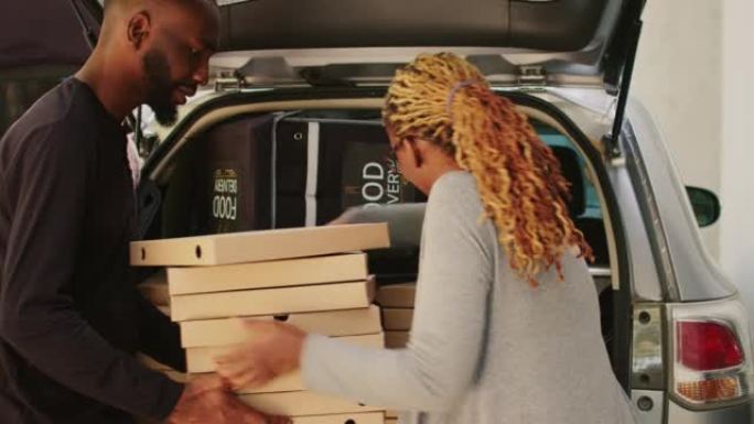 非裔美国女快递员拿走了一大堆披萨盒