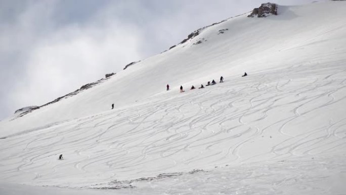 一群人在国外滑雪和单板滑雪，自由式滑雪和滑雪板在深深的粉末雪中。极限冬季运动