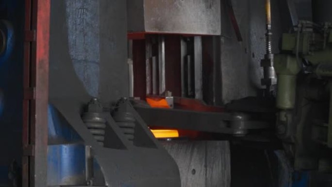 铁匠工厂。用工业锻压机锻造大型热金属坯。金属锻造厂的技术设备。大型机器，铁匠移动并加热金属，并为轨道