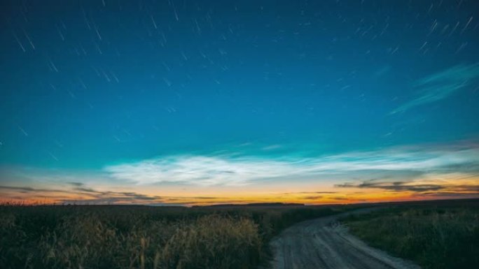 4k延时在春季春季夏季的乡村乡村田地景观上产生不寻常的云和星星效应，带有年轻的绿色麦芽。云和星星踪迹