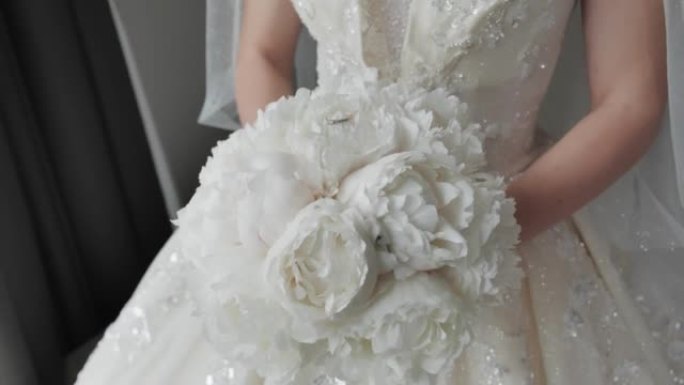 新娘穿着奢华的婚纱，带着一束鲜花