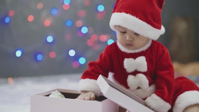 圣诞节在家带礼品盒的女婴。