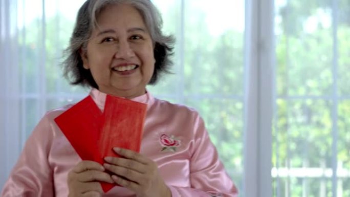 亚洲资深女性在农历新年展示幸运红包