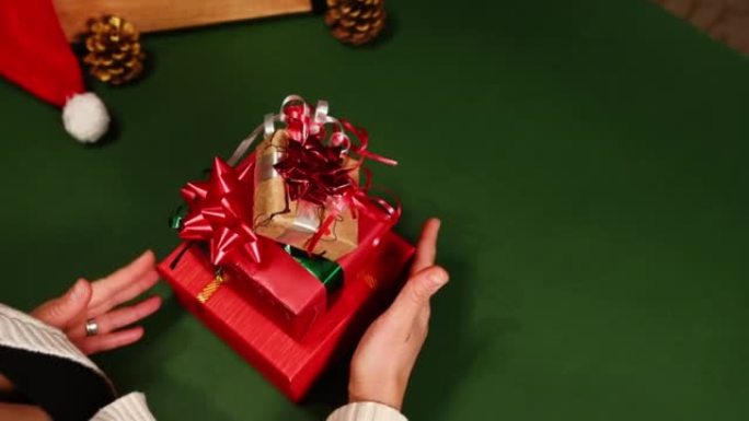 顶视图女人堆叠圣诞礼品盒，一对一，在绿色背景上盘旋，并带有复制广告空间。