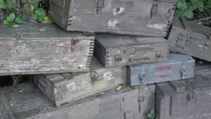 一叠装有弹药的旧木制军用绿色盒子。