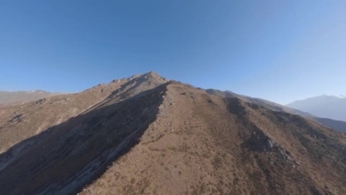 悬崖山脊石纹理沙漠谷雪峰清澈蓝天鸟瞰图