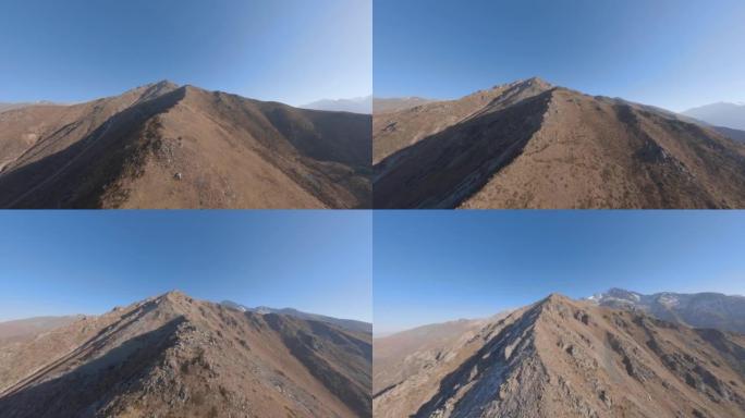 悬崖山脊石纹理沙漠谷雪峰清澈蓝天鸟瞰图