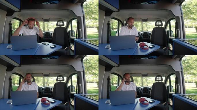 中年男子在公路旅行中与露营车上的笔记本电脑进行视频会议