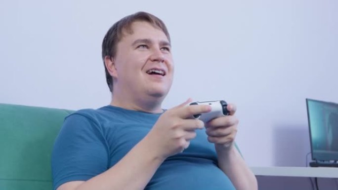 男子手持操纵杆，在玩视频游戏时鲁ck地按下按钮。