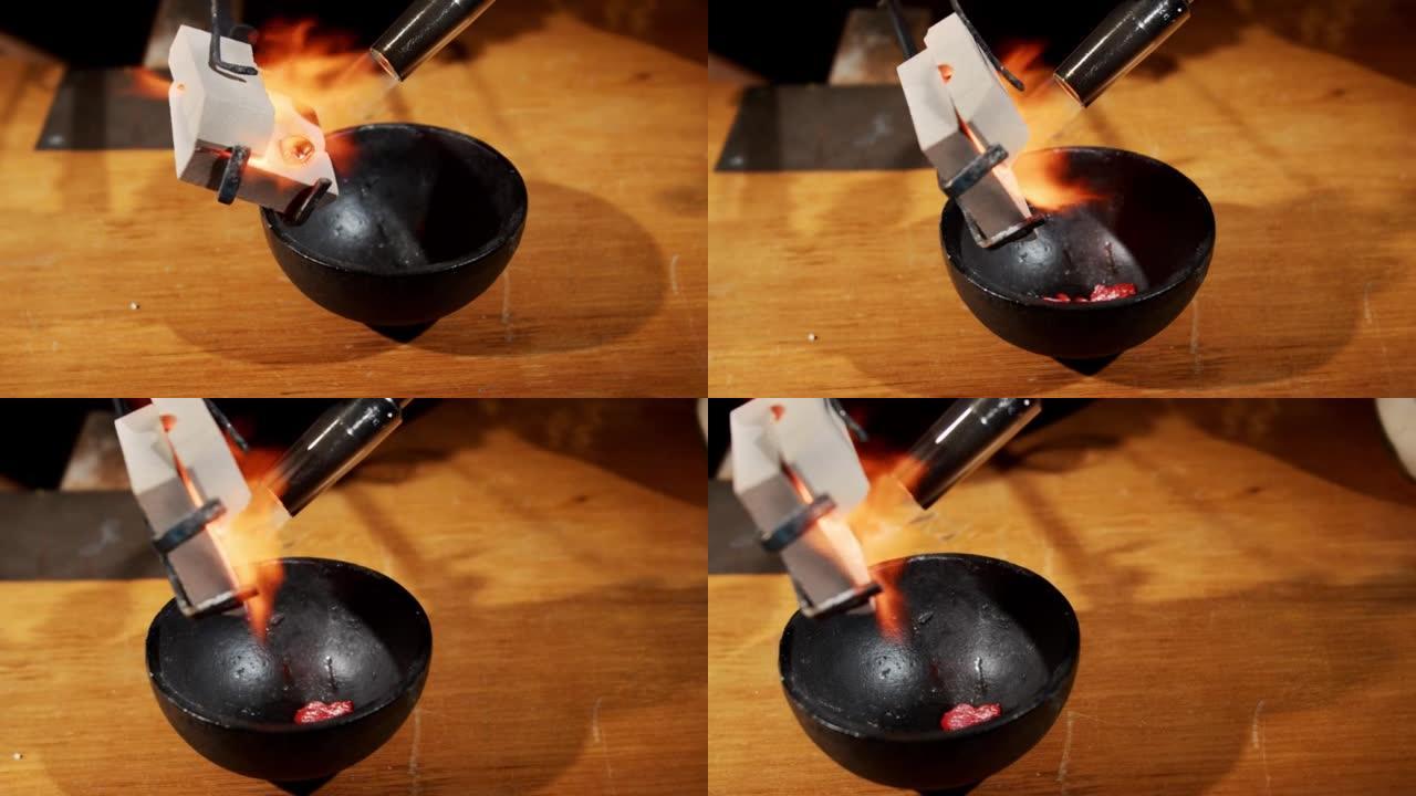 在煤气火下用预热的金料填充黑碗的过程