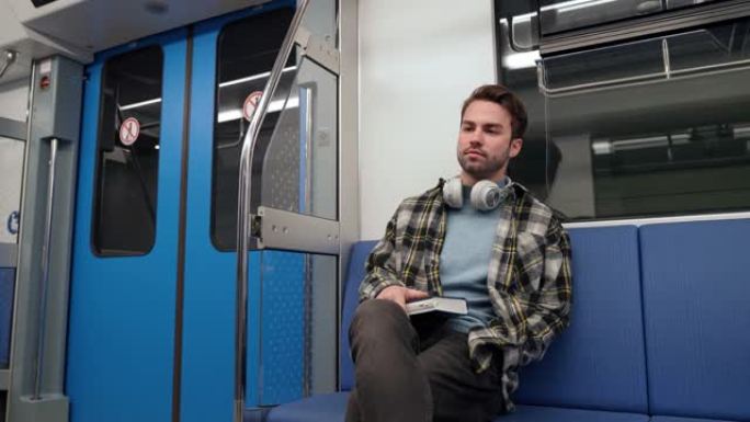 年轻人坐地铁，专注于公共交通工具的学生，疲惫的家伙回家。