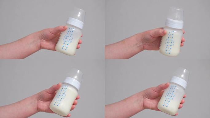 母亲用婴儿配方奶粉摇透明奶瓶