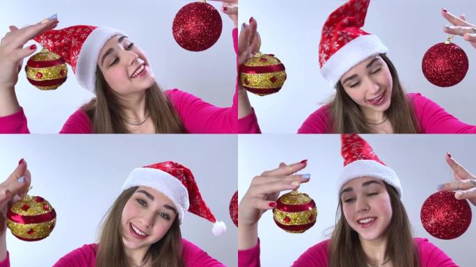新年玩具在手女孩手里拿着新年玩具她微笑着，让相框里的脸看着相机。背景是白色的。她戴着一顶帽子。一件粉