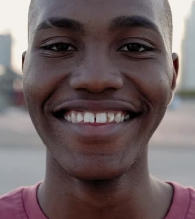 微笑的年轻非洲裔美国人站在户外的肖像