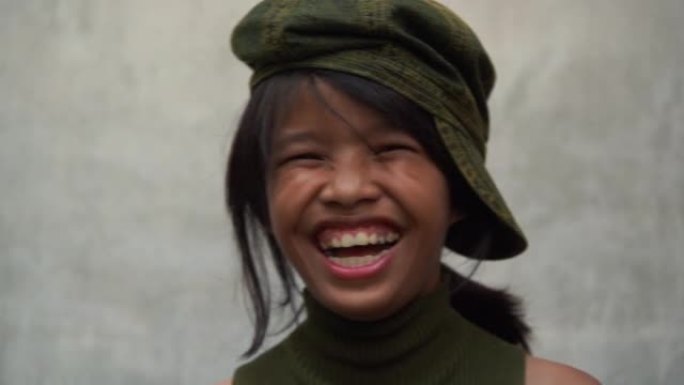 亚洲十几岁的时髦女孩摆姿势观看病毒视频，并在白色旧墙壁背景上大笑
