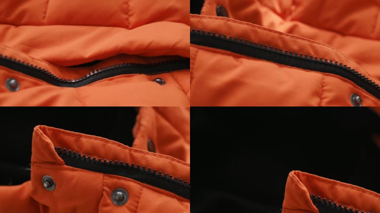 冬季夹克、羽绒服橙色防水面料特写细节。夹克上的拉链，铆钉纽扣。纺织、材料、服装生产。时尚，时尚。衣服