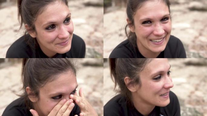 一名年轻女子徒步旅行者激动或高兴地哭泣，边说话边擦干眼泪，摇头看着镜头的视频。