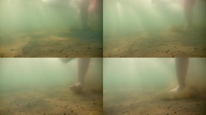 在海底行走。从下面观察水面，太阳光线穿透水面。