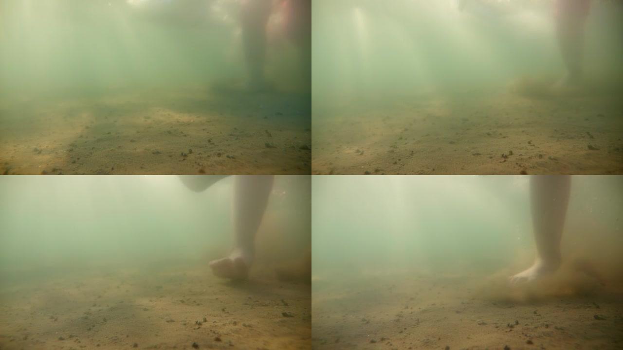在海底行走。从下面观察水面，太阳光线穿透水面。