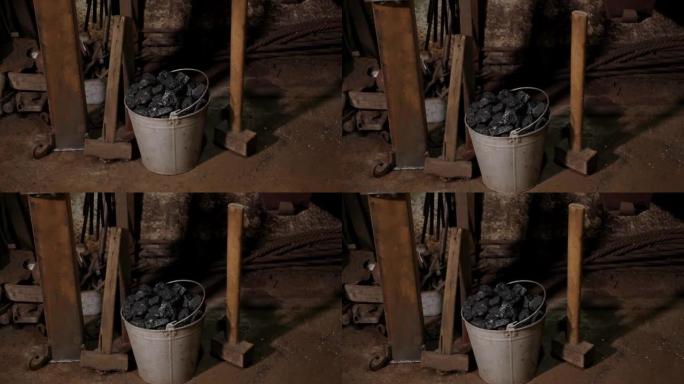 伪造桶中煤的特写镜头。锻造中的工作场所。