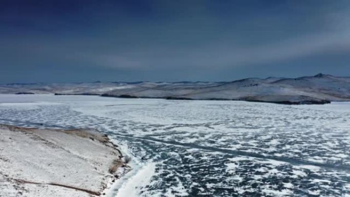 辽阔的贝加尔湖在黑暗的天空，裸露的冰，冬天的蓝色。无人机航拍4k