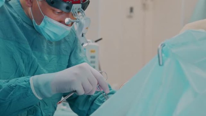外科医生操作口腔区域，用烧灼笔烧灼伤口内部，并使用手术剪刀和镊子进行手术