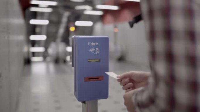 一名男子在德国慕尼黑为验证运输系统的机器上验证车票。公共交通服务。人员将纸质票证插入验证器机器以进行