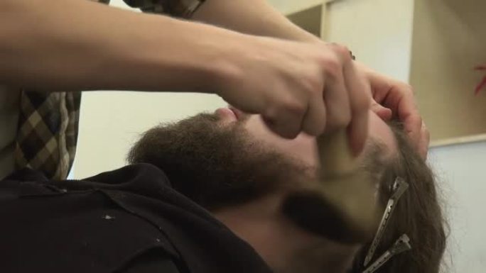 理发师在客户热剃须时使用颈部除尘器