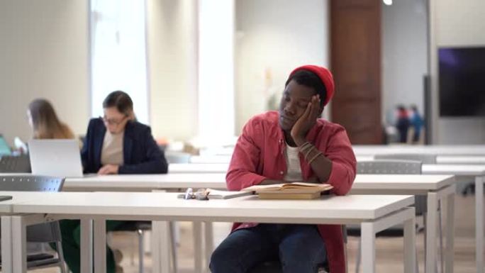 疲惫的非洲学生在图书馆学习时睡觉。学习乏力